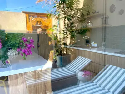 a kitchen with a counter with purple flowers and plants at DUNE Villas in Seminyak