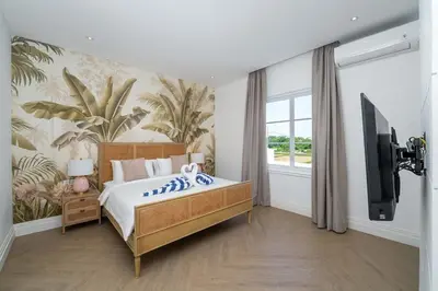 a bedroom with a large bed and a tv at Villa Aclasa Luxery 4BR Retreat in Berawa, Canggu in Canggu