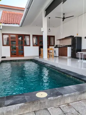 a swimming pool in the middle of a house at Villa Cassia Jimbaran in Jimbaran