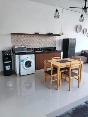 a kitchen with a table and two chairs and a stove at Villa Cassia Jimbaran in Jimbaran