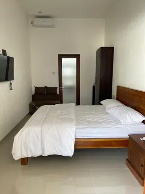 a bedroom with a large bed and a television at Villa Cassia Jimbaran in Jimbaran