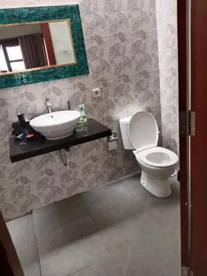 a bathroom with a toilet and a sink and a mirror at Villa Cassia Jimbaran in Jimbaran