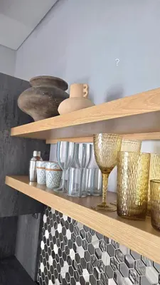a shelf with bowls and vases on it at Villa Mannah - Managed By Chayah Bali Villa Group in Kuta
