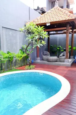 a swimming pool in front of a building with a gazebo at Villa Mannah - Managed By Chayah Bali Villa Group in Kuta