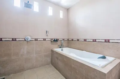 a large bathroom with a tub and a mirror at Villa Nakula - Managed By Chayah Bali Villa Group in Seminyak