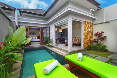 a villa with a swimming pool in front of a house at Maharaja Villas Seminyak by Humus Hospitality in Kerobokan