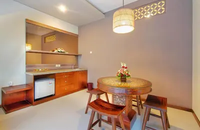 a kitchen with a table and chairs and a counter at Maharaja Villas Seminyak by Humus Hospitality in Kerobokan
