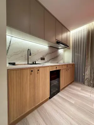 a kitchen with wooden cabinets and a sink at MODERN 2 BEDROOM LAVAYA OAKWOOD APARTMENT, Nusa Dua in Nusa Dua