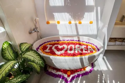 a bathroom with a bath tub covered in flowers at Brand New Villa 2BR with Private Pool near Seminyak by BaliSuperHost in Seminyak