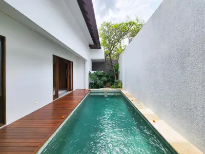 a swimming pool in the middle of a house at Silk Umalas by Nagisa Bali in Kerobokan