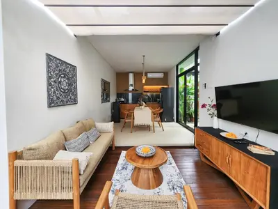 a living room with a couch and a large television at Silk Umalas by Nagisa Bali in Kerobokan