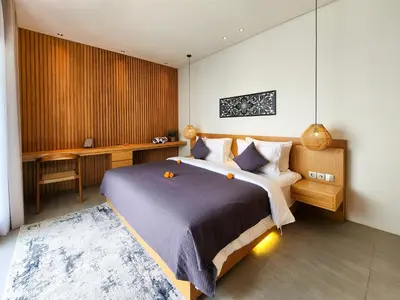a bedroom with a large bed and a desk at Silk Umalas by Nagisa Bali in Kerobokan