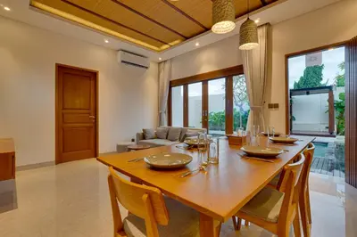 a dining room with a wooden table and chairs at New! Villa Taman Seminyak 01 near Double Six Beach in Seminyak