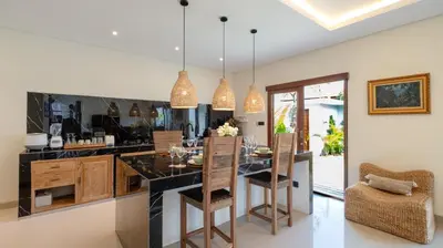 a kitchen with a black counter and a dining room at The Lange Estate in Seminyak