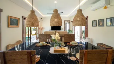a dining room with a table with chairs and glasses at The Lange Estate in Seminyak