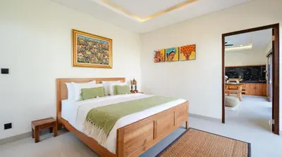 a bedroom with a large bed and a mirror at The Lange Estate in Seminyak