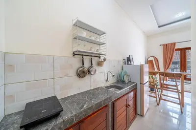 a kitchen with a sink and a refrigerator at Jimbaran Retreat in Jimbaran
