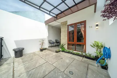 a patio of a house with a blue bench at Jimbaran Retreat in Jimbaran