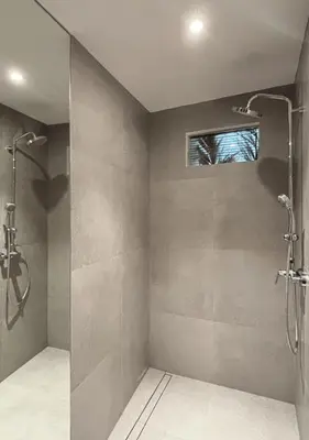 a bathroom with a shower stall and a window at Tropical Townhouse 3 Bedrooms Seminyak in Seminyak