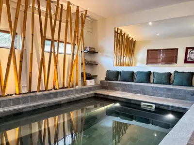 a house with a swimming pool with a couch at Tropical Townhouse 3 Bedrooms Seminyak in Seminyak