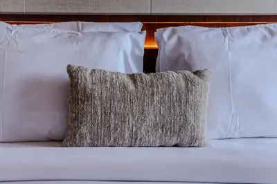 a pillow sitting on top of a bed with white pillows at Homely Bali at Seminyak in Kerobokan