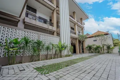 a building with a fence and plants in front of it at Homely Bali at Seminyak in Kerobokan