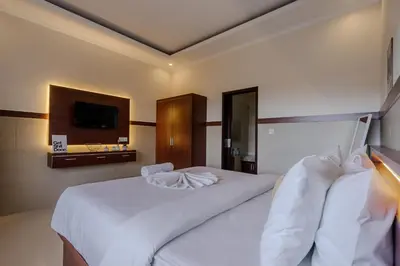 a hotel room with two beds and a television at Homely Bali at Seminyak in Kerobokan