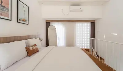a bedroom with a large white bed and a window at Villa Azura in Perean