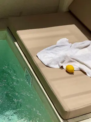 a towel sitting on a bed next to a swimming pool at Villa Azura in Perean
