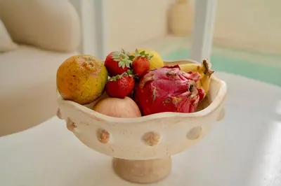 a wooden bowl filled with fruit on a table at Villa Azura in Perean
