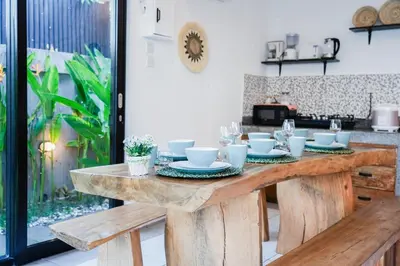 a wooden table with cups and plates on it in a kitchen at Peaceful private 3BR pool villa in heart of Bali in Legian