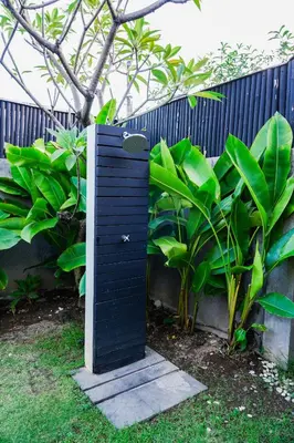 a black door in front of a fence with plants at Peaceful private 3BR pool villa in heart of Bali in Legian