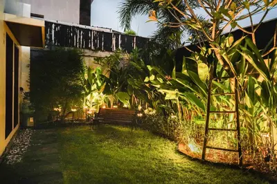 a garden with a bench in the grass at Peaceful private 3BR pool villa in heart of Bali in Legian