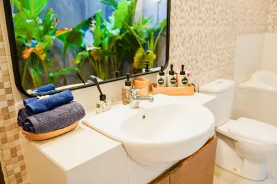 a bathroom with a sink and a toilet and a mirror at Peaceful private 3BR pool villa in heart of Bali in Legian