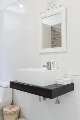 a white bathroom with a sink and a mirror at Walk to Beach - Private 3 Bedroom Villa Roshi Seminyak in Seminyak