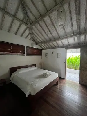 a bedroom with a large bed and a large window at Villa Louise in Badung