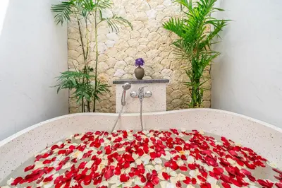 a table with a bunch of red flowers on it at A26 - Private Pool Villa in Seminyak in Seminyak
