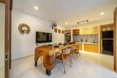 a dining room with a wooden table and chairs at Mirragold Villa - Sun, Pool and Views - Brand New 3BDR Villa in Kerobokan