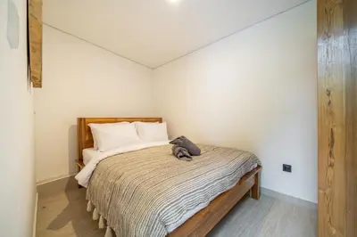 a small bedroom with a bed with white walls at Mirragold Villa - Sun, Pool and Views - Brand New 3BDR Villa in Kerobokan