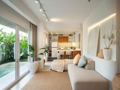 a living room with a couch and a kitchen at Berawa Luxury Retreat - The Cruise Canggu in Canggu