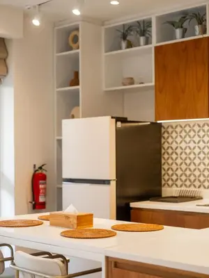 a kitchen with a refrigerator and a table with chairs at Berawa Luxury Retreat - The Cruise Canggu in Canggu