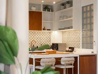 a kitchen with a counter with stools in it at Berawa Luxury Retreat - The Cruise Canggu in Canggu