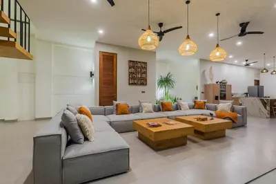 a living room with a couch and a table at Villa Trindade 5BR, 15m Pool in Seminyak