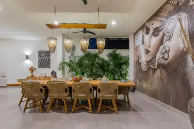 a dining room with a large wooden table and chairs at Villa Trindade 5BR, 15m Pool in Seminyak
