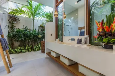 a bathroom with a sink and a mirror and plants at Villa Trindade 5BR, 15m Pool in Seminyak