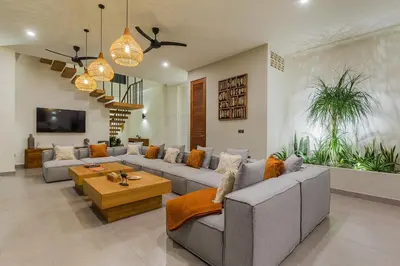 a living room with a couch and a table at Villa Trindade 5BR, 15m Pool in Seminyak