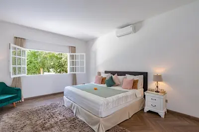 a white bedroom with a large bed and a window at The Heritage 4BR Villa Luxury Oasis in Canggu