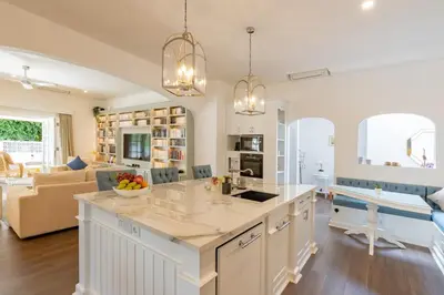 a kitchen and living room with a large island at The Heritage 4BR Villa Luxury Oasis in Canggu