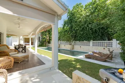 a backyard with a swimming pool and a house at The Heritage 4BR Villa Luxury Oasis in Canggu