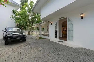 a car parked in front of a white house at The Heritage 4BR Villa Luxury Oasis in Canggu
